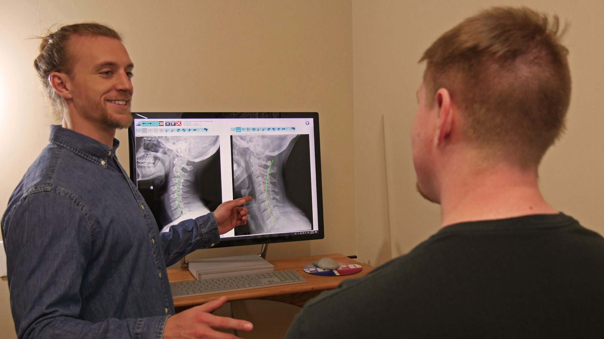 Dr. Duff reviewing digital cervical spine x-rays with a patient